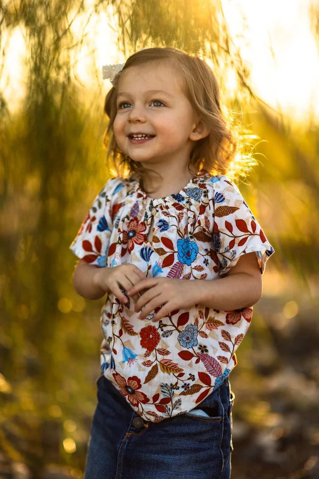 Young girl in a floral shirt glowing in golden backlight at Tule Springs
