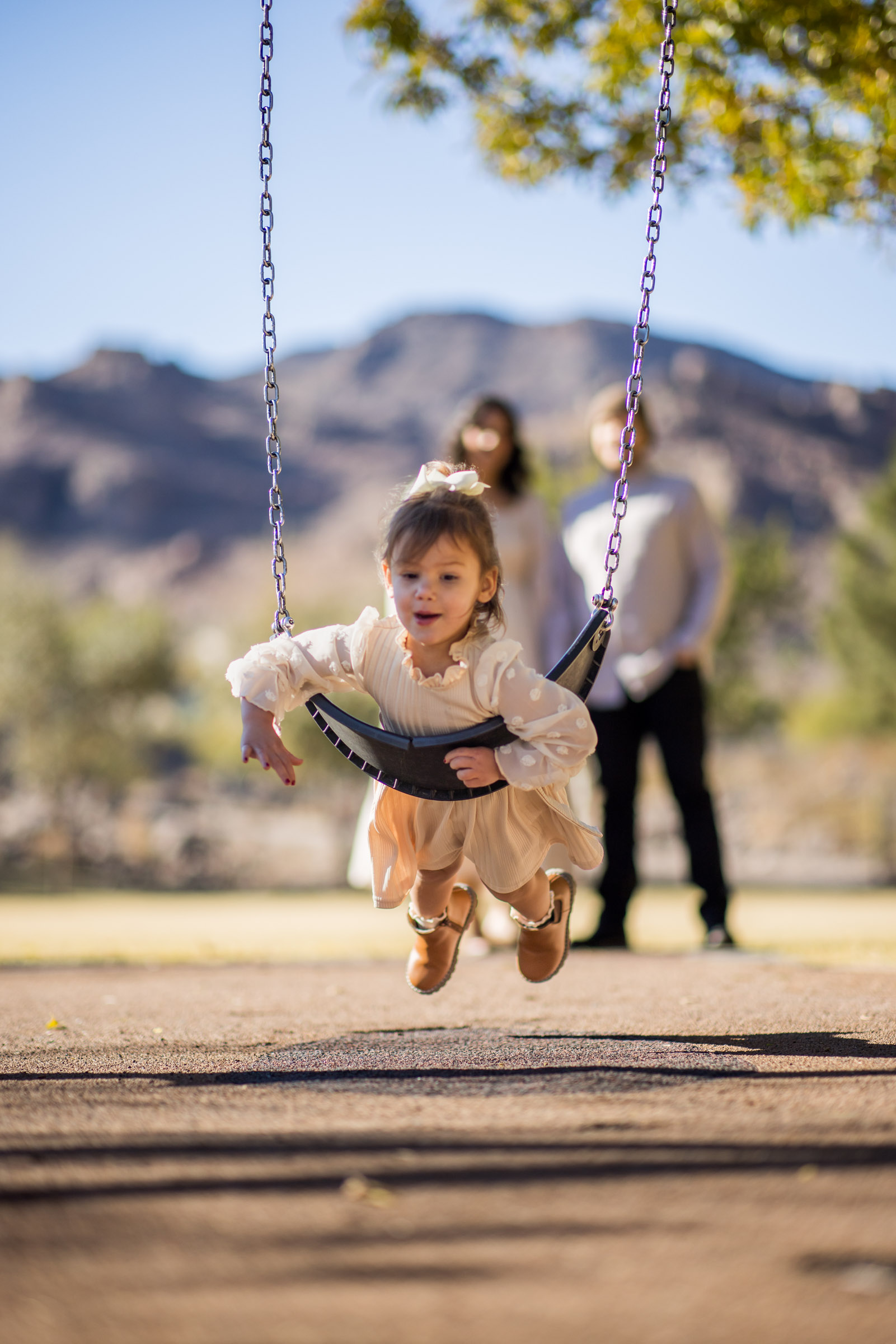 Parents swinging their child during a playful outdoor family session