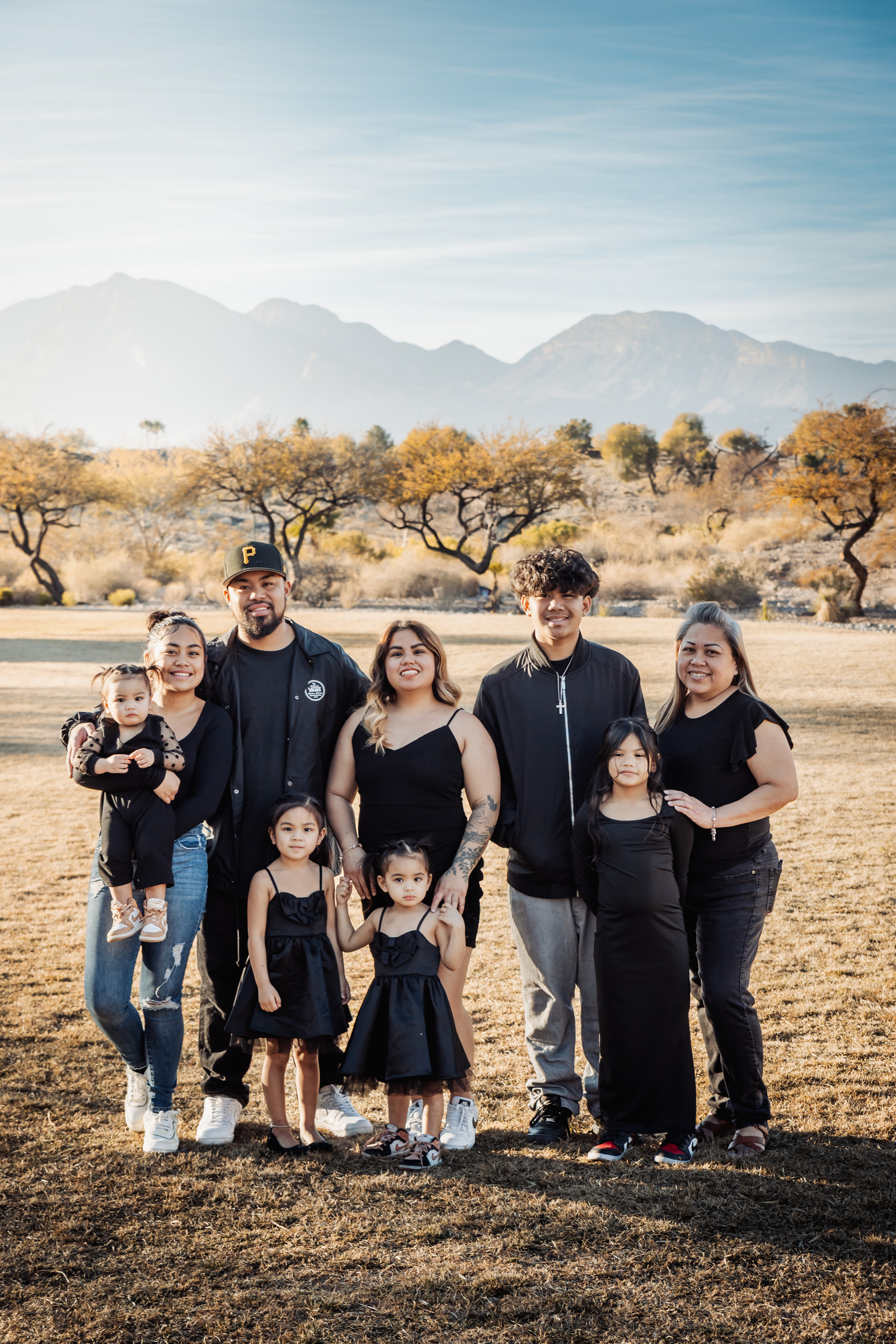 Family of nine in matching black outfits in front of the mountains in Summerlin, Las Vegas
