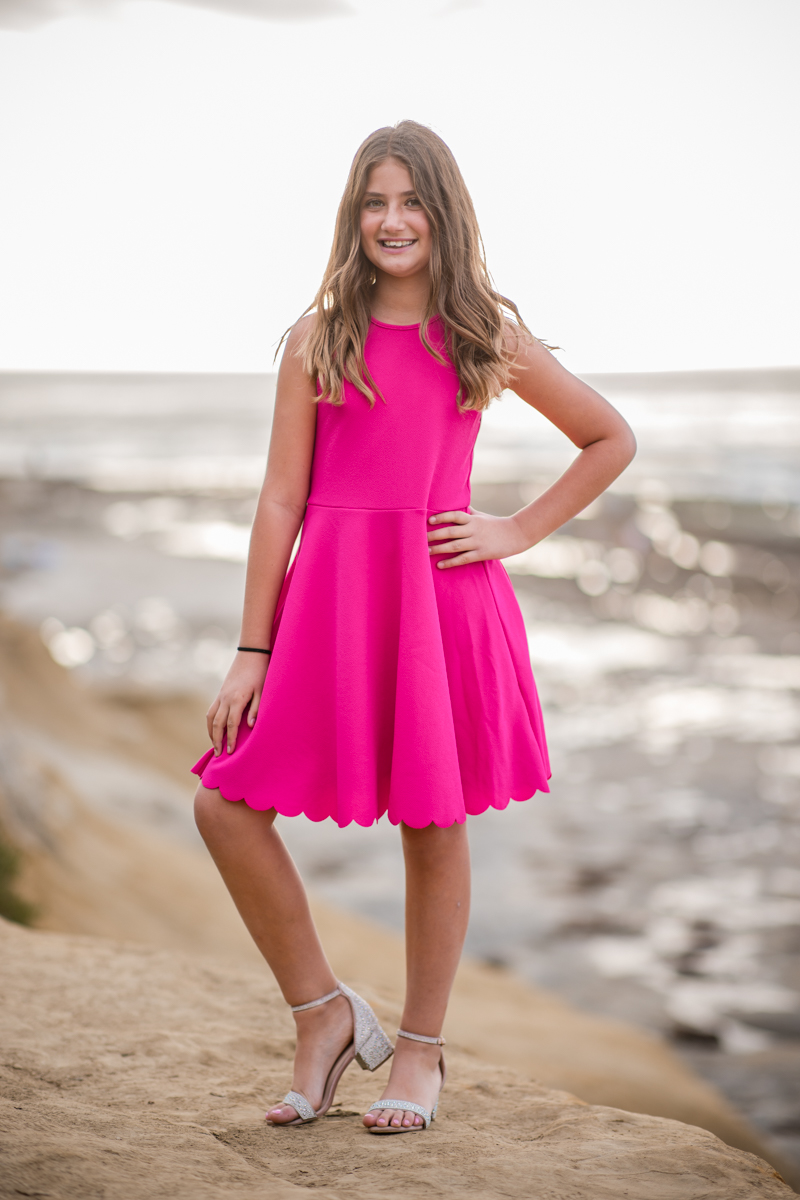 Girl posing confidently above the ocean during a portrait session